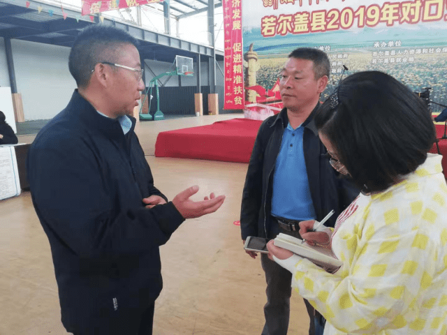 若尔盖县委副书记,县长余开勇(左一)接受记者采访.
